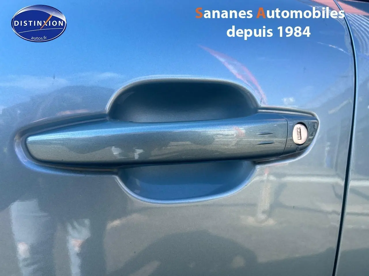 Poignée de porte avant droite bleu clair métallisé d'une Citroën C4 2021 avec serrure visible.