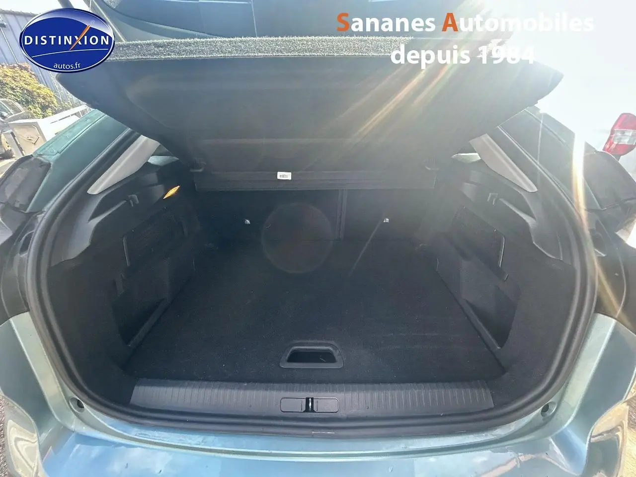 Coffre ouvert vu de l'arrière d'une Citroën C4 bleu clair 2021, montrant un espace de chargement vide et propre.