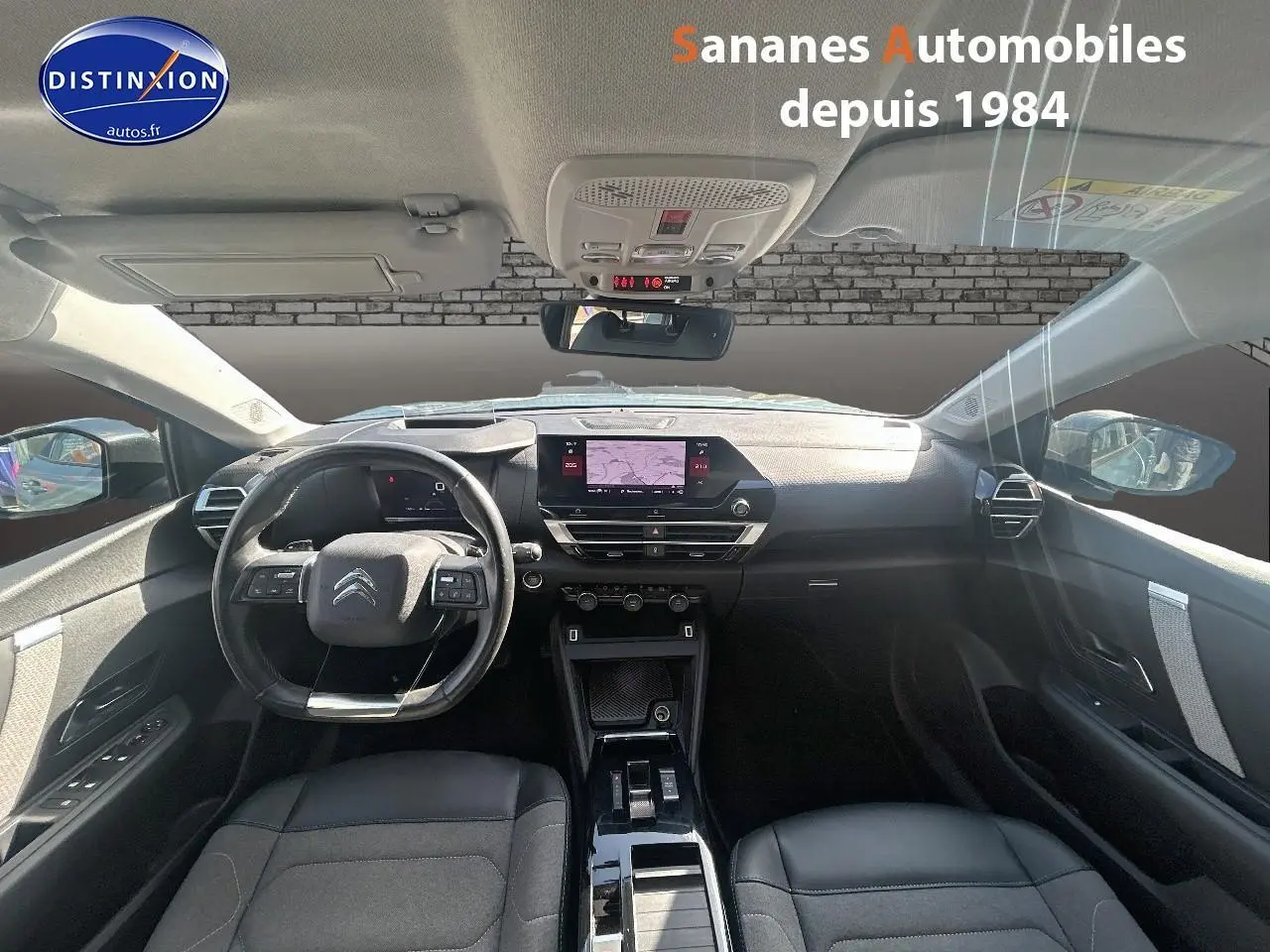 Vue intérieure avant de la Citroën C4 2021, tableau de bord moderne avec écran tactile et sièges noirs en textile et cuir.