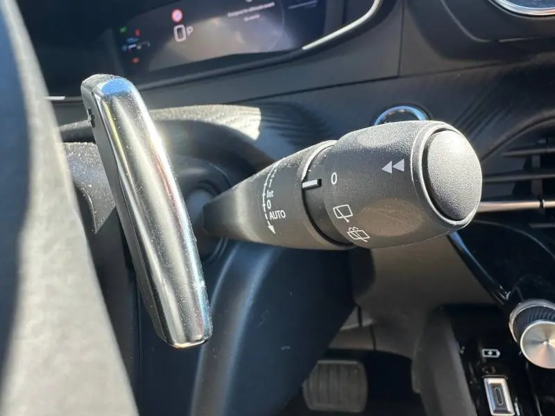 Gros plan sur la commande d'essuie-glace à gauche du volant dans l'habitacle du Peugeot 2008 Bleu Obsession 2025.