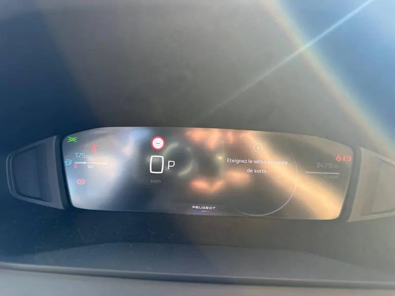 Affichage numérique du tableau de bord du Peugeot 2008 hybride, avec indication de vitesse à 0 km/h et message d'arrêt.
