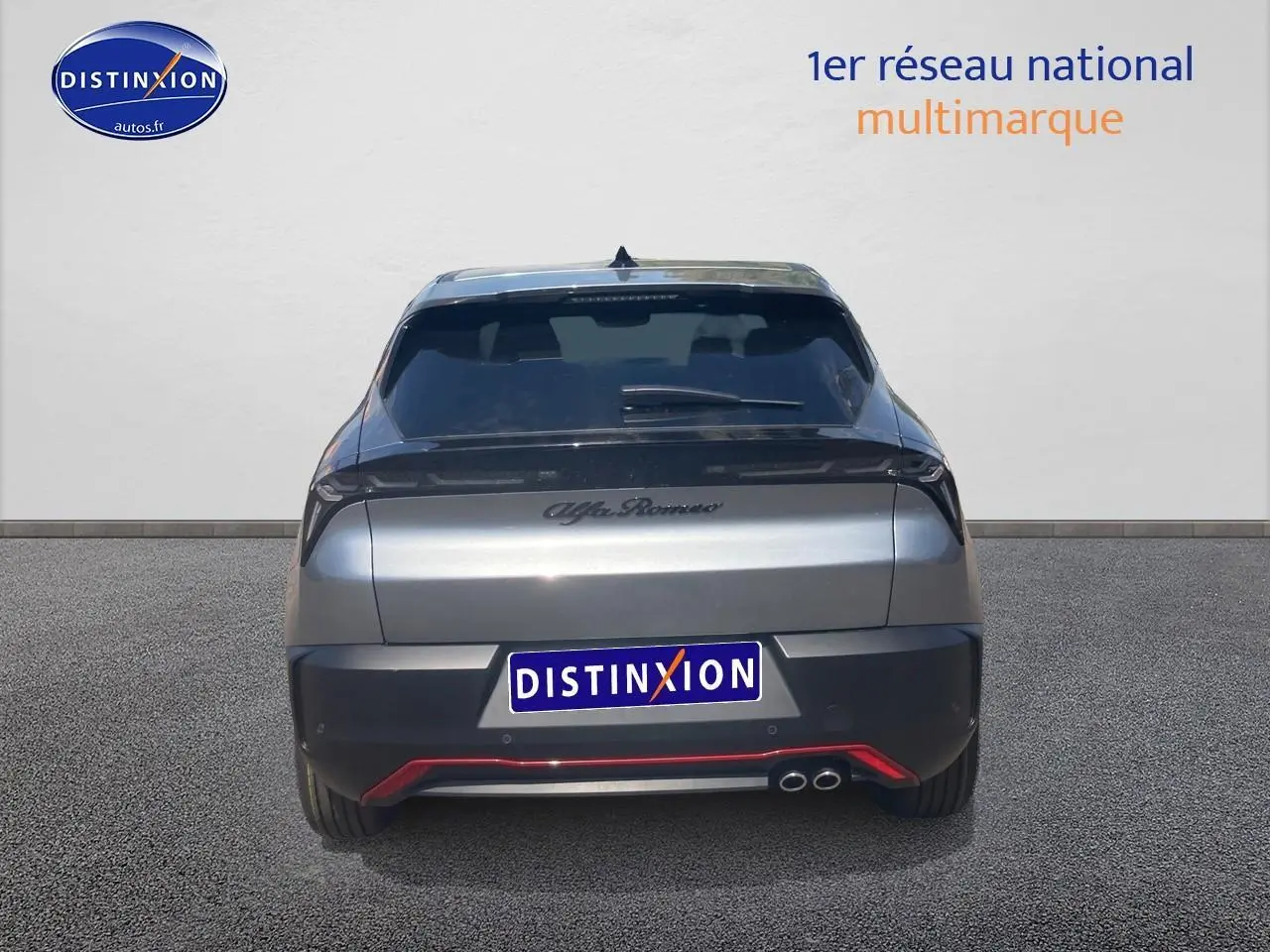 Vue arrière d'une Alfa Romeo Junior 1.2 hybride grise avec feux arrière LED et double sortie d'échappement chromée.