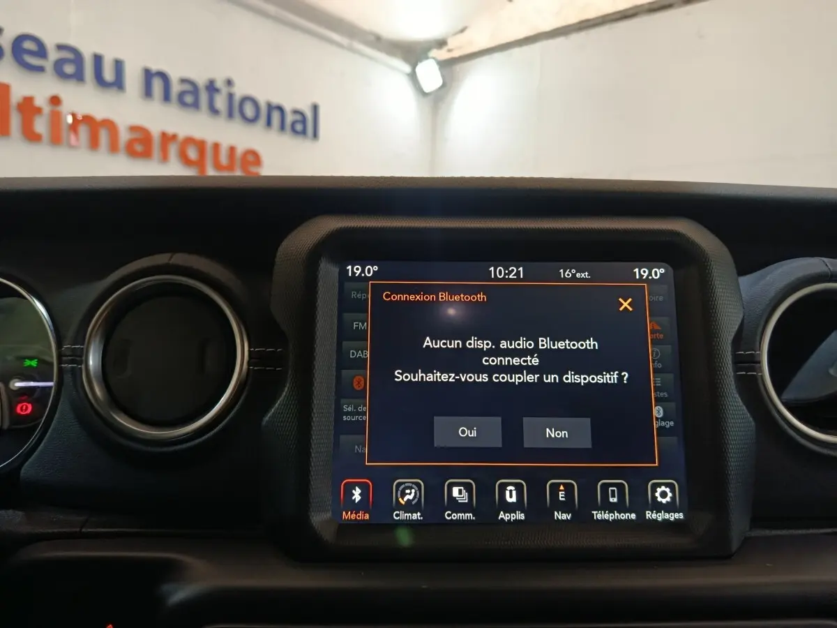 Écran tactile central du tableau de bord d'une Jeep Wrangler 2022 gris foncé, affichant une connexion Bluetooth.