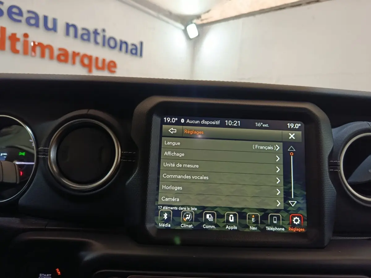 Vue intérieure centrée sur l'écran tactile multifonctions du tableau de bord d'une Jeep Wrangler gris foncé.
