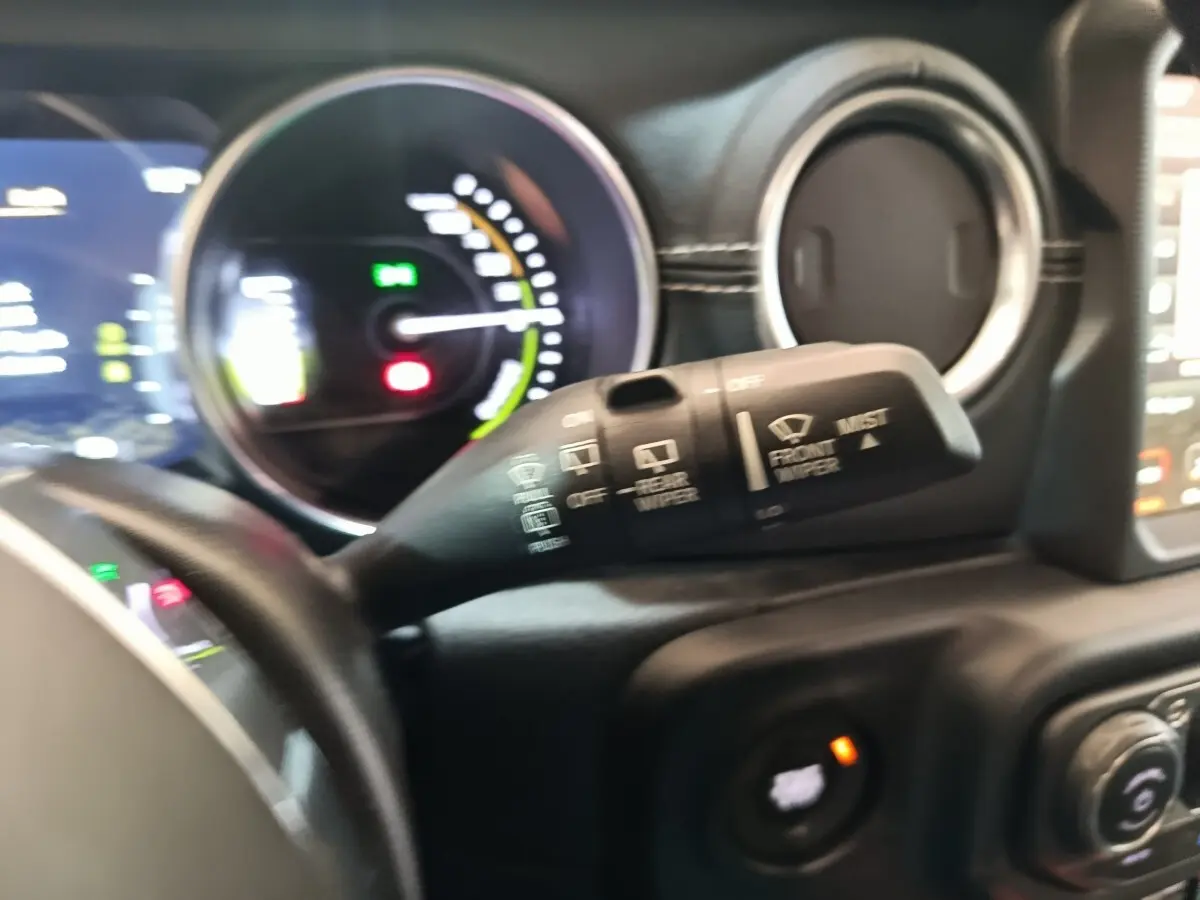 Gros plan sur la commande d’essuie-glace et le tableau de bord du Jeep Wrangler 2022, intérieur noir.