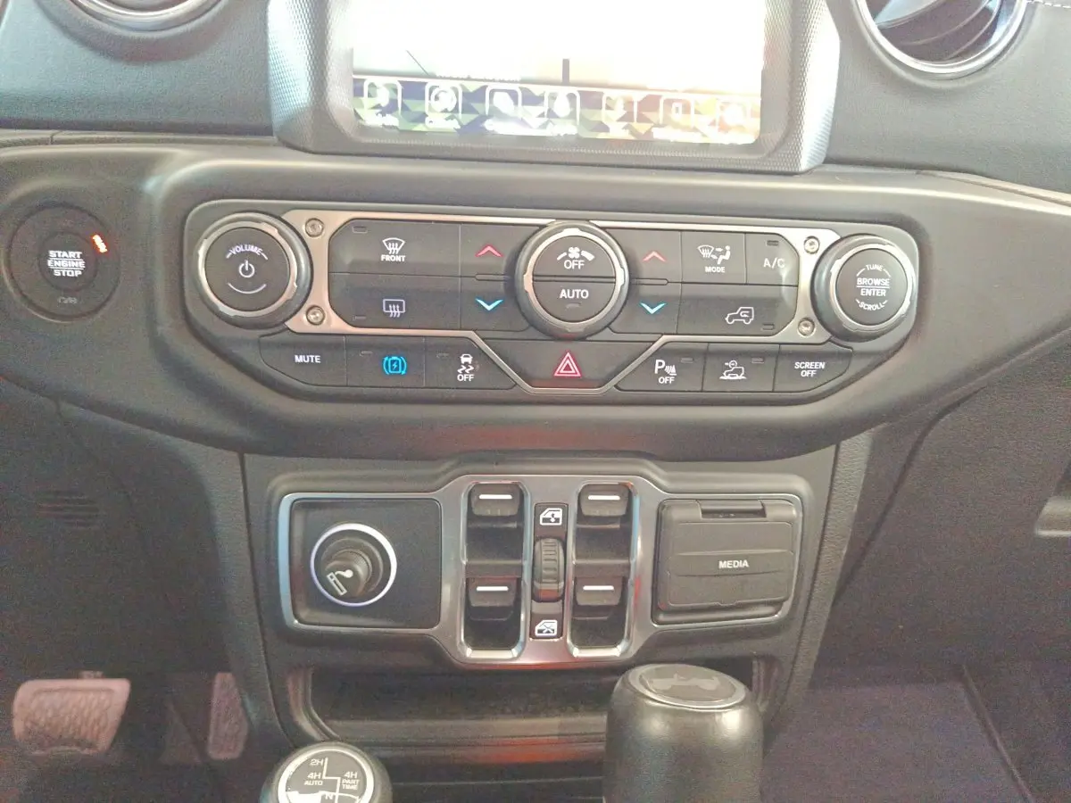 Vue rapprochée du tableau de bord central et des commandes de climatisation du Jeep Wrangler gris foncé 2022.