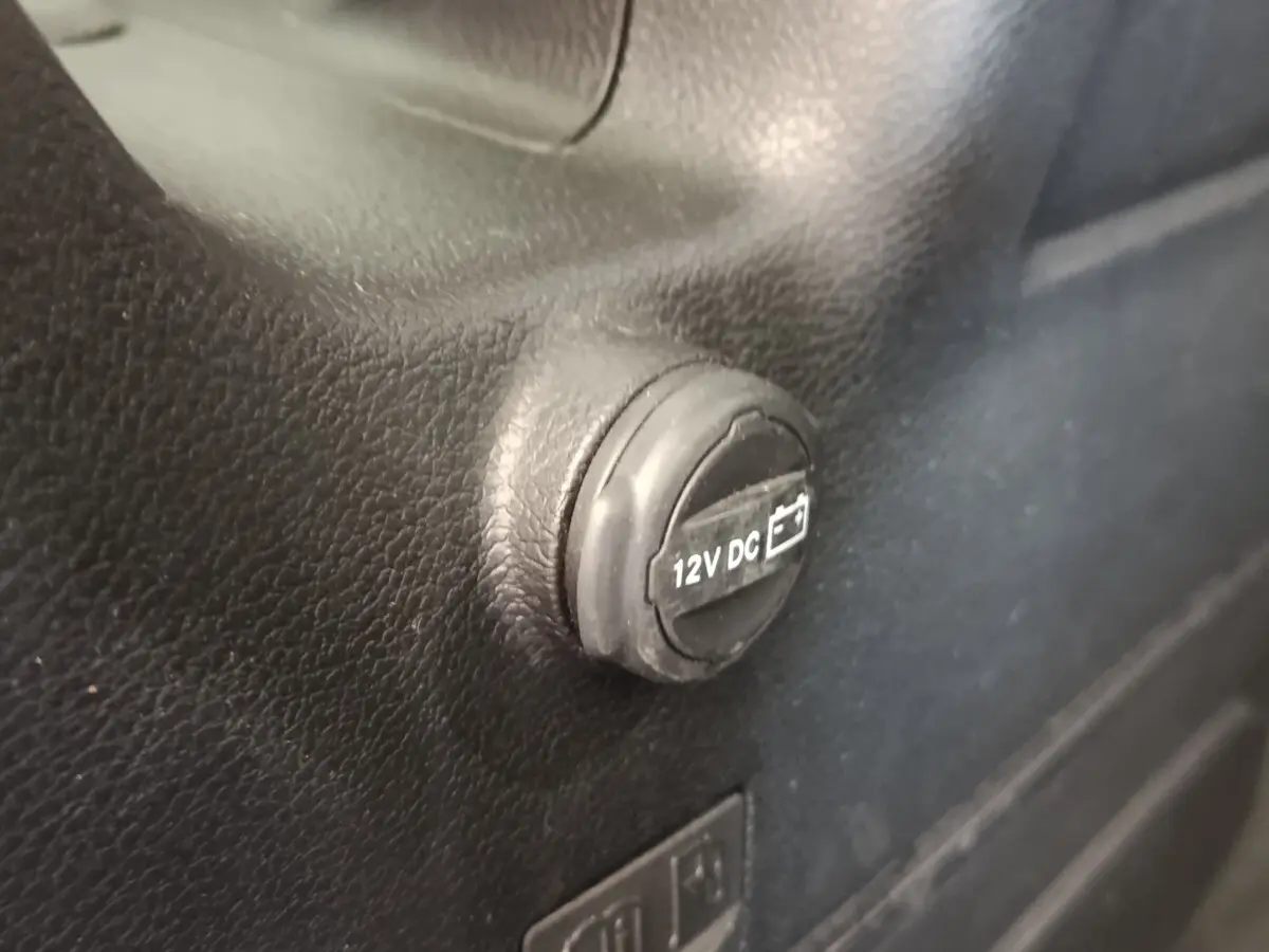 Gros plan sur la prise 12V DC noire intégrée dans l’habitacle du Jeep Wrangler gris foncé 2022.