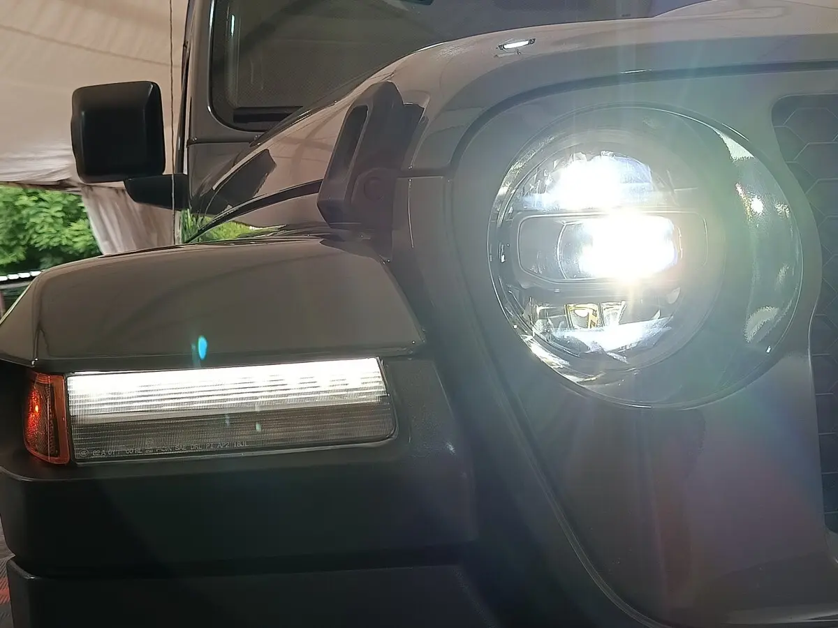 Gros plan sur l'avant droit gris foncé du Jeep Wrangler 2022 avec phare LED allumé et clignotant latéral visible.