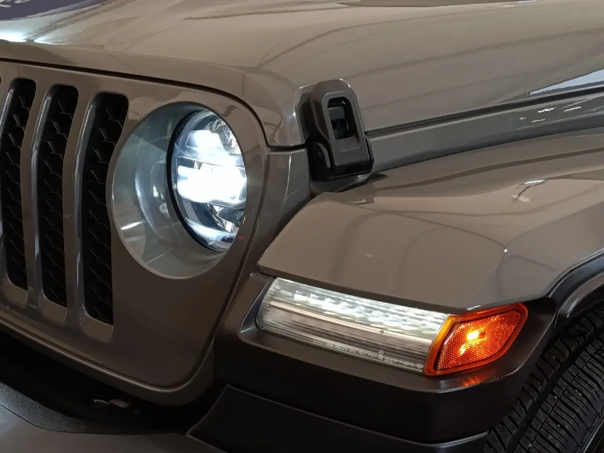 Gros plan sur l’avant droit gris foncé du Jeep Wrangler 2022, phare LED allumé et clignotant orange visible.