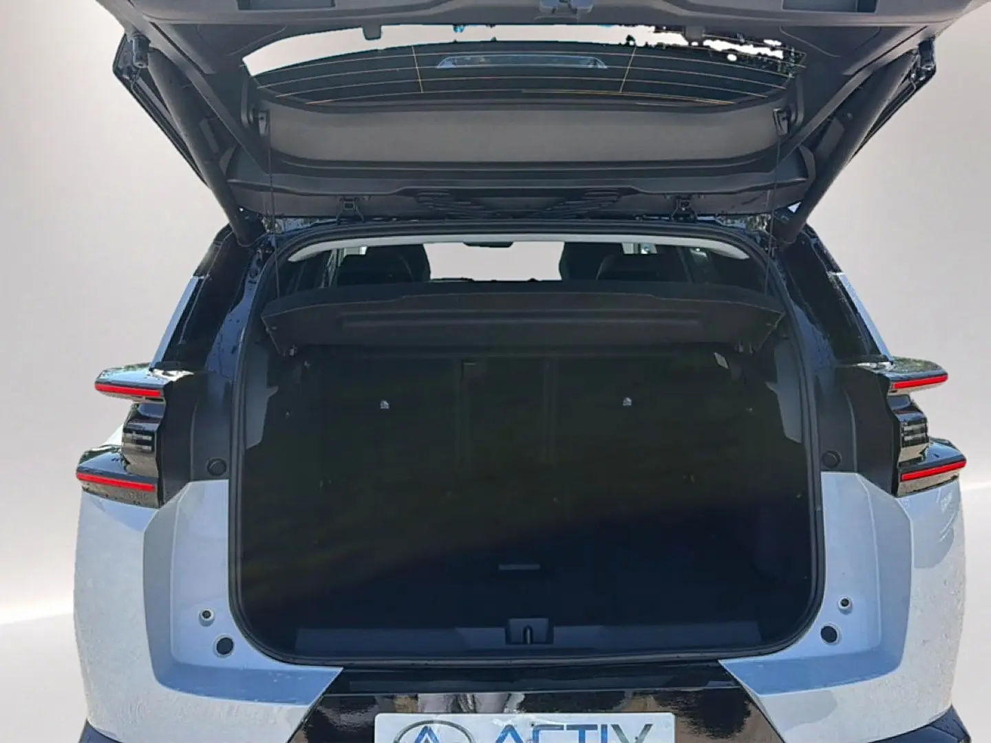 Vue arrière du Citroën C5 Aircross hybride 2026 blanc et noir avec coffre ouvert et feux arrière LED distinctifs.