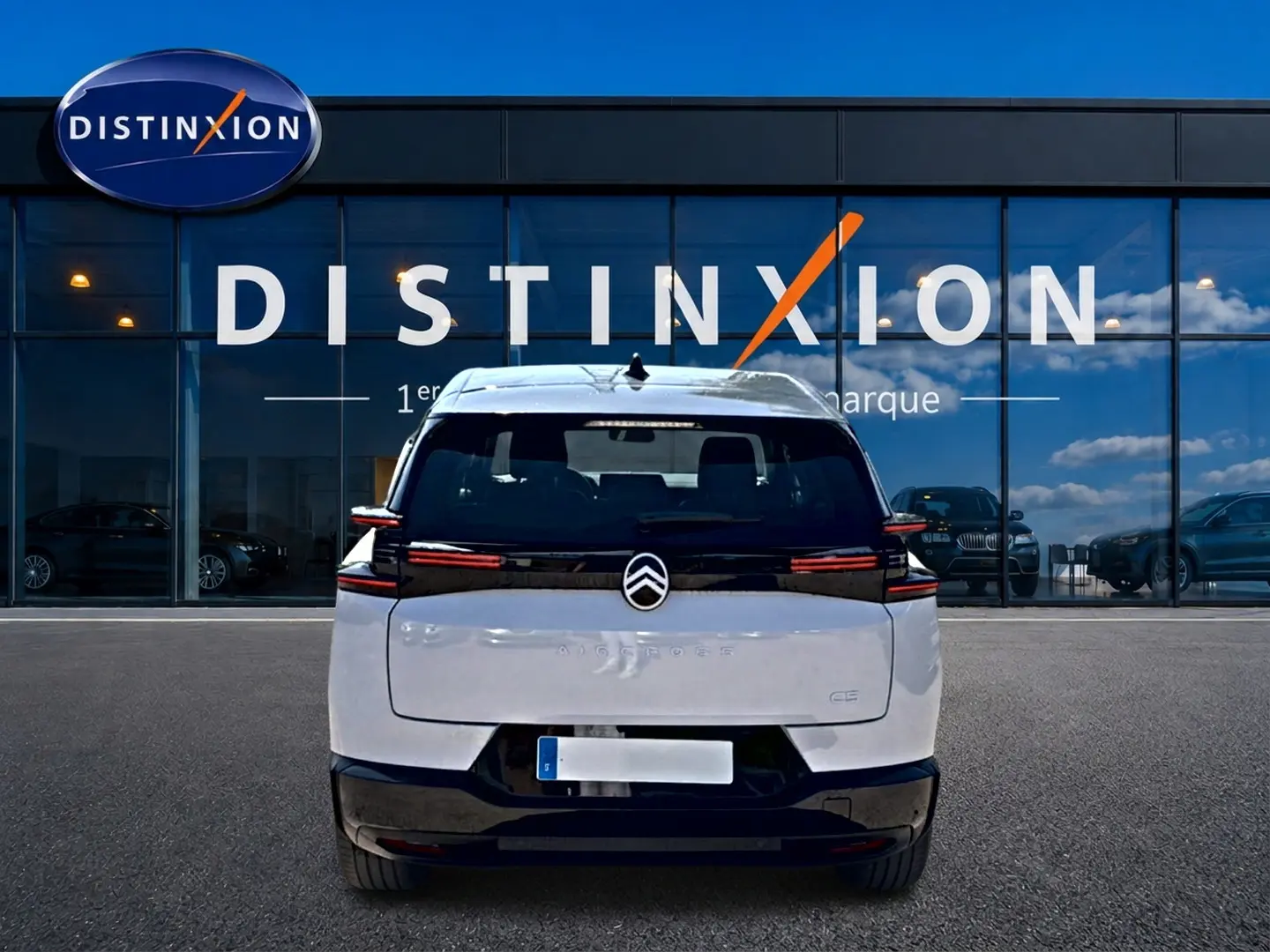 Vue arrière d'un Citroën C5 Aircross blanc et noir avec feux LED horizontaux, devant une vitrine Distinxion.
