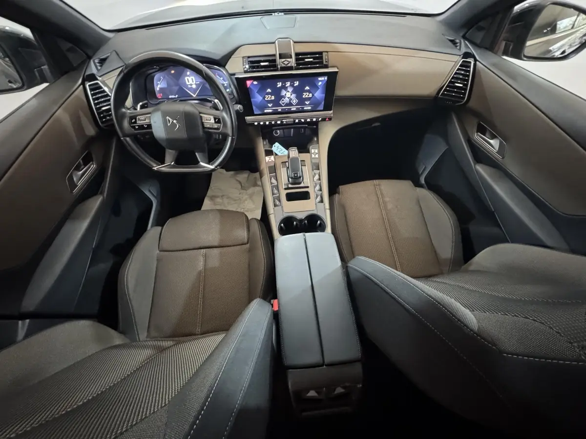 Vue intérieure avant du DS7 Crossback gris foncé, mettant en valeur le tableau de bord digital et l'écran tactile central.