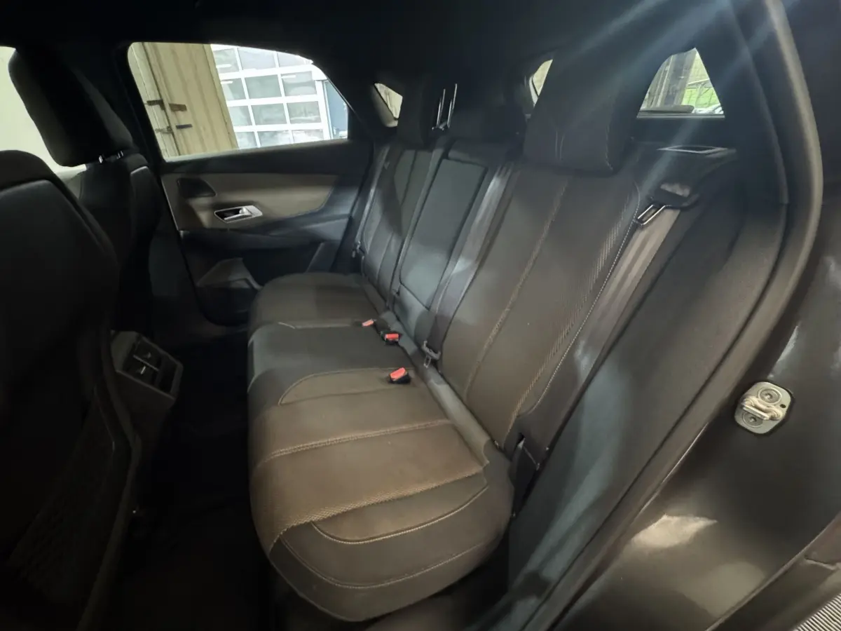 Vue intérieure arrière côté droit du DS7 Crossback gris foncé, montrant la banquette en cuir et les ceintures de sécurité.