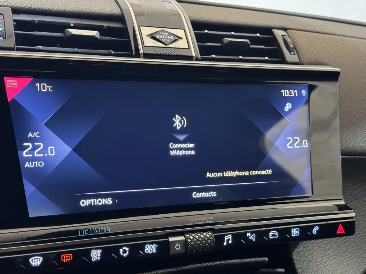 Vue rapprochée de l'écran tactile central du DS7 Crossback gris foncé, affichant la connexion Bluetooth et la climatisation à 22°C.