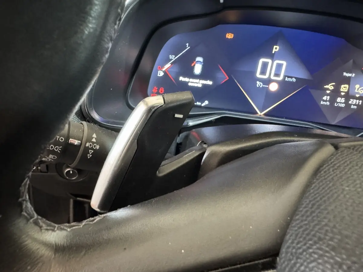 Gros plan sur le levier de vitesse et le tableau de bord numérique bleu du DS7 Crossback PureTech 130.
