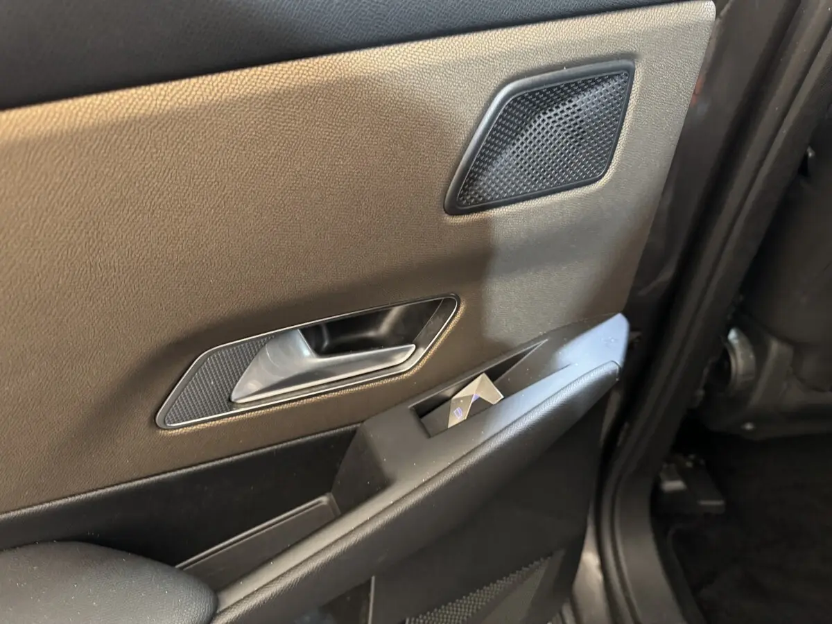 Gros plan sur la porte intérieure côté gauche du DS7 Crossback 2020, avec garniture beige et commandes de vitre.