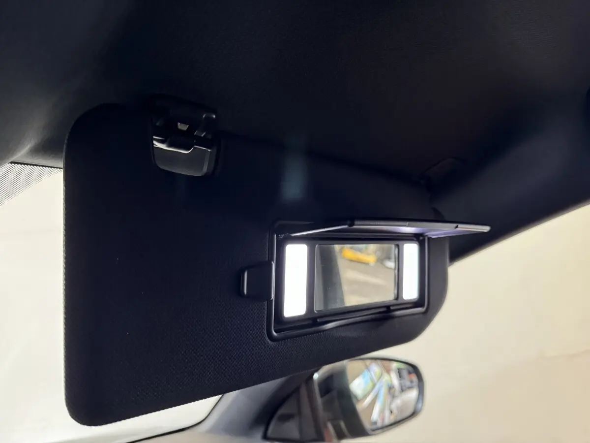 Détail du miroir de courtoisie éclairé sur le pare-soleil côté conducteur du DS7 Crossback gris foncé, intérieur visible.