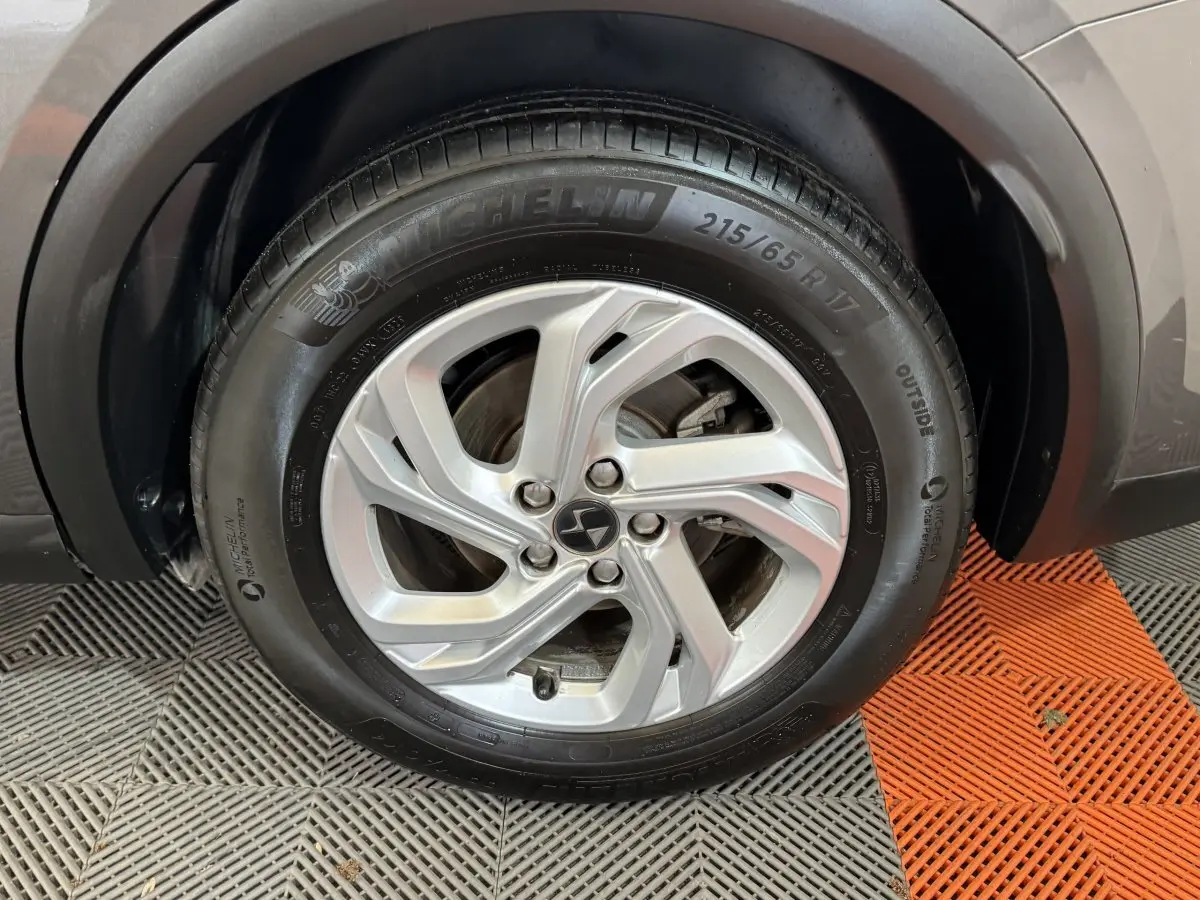 Gros plan sur la roue avant droite du DS7 Crossback gris foncé, jante alliage et pneu Michelin visible.