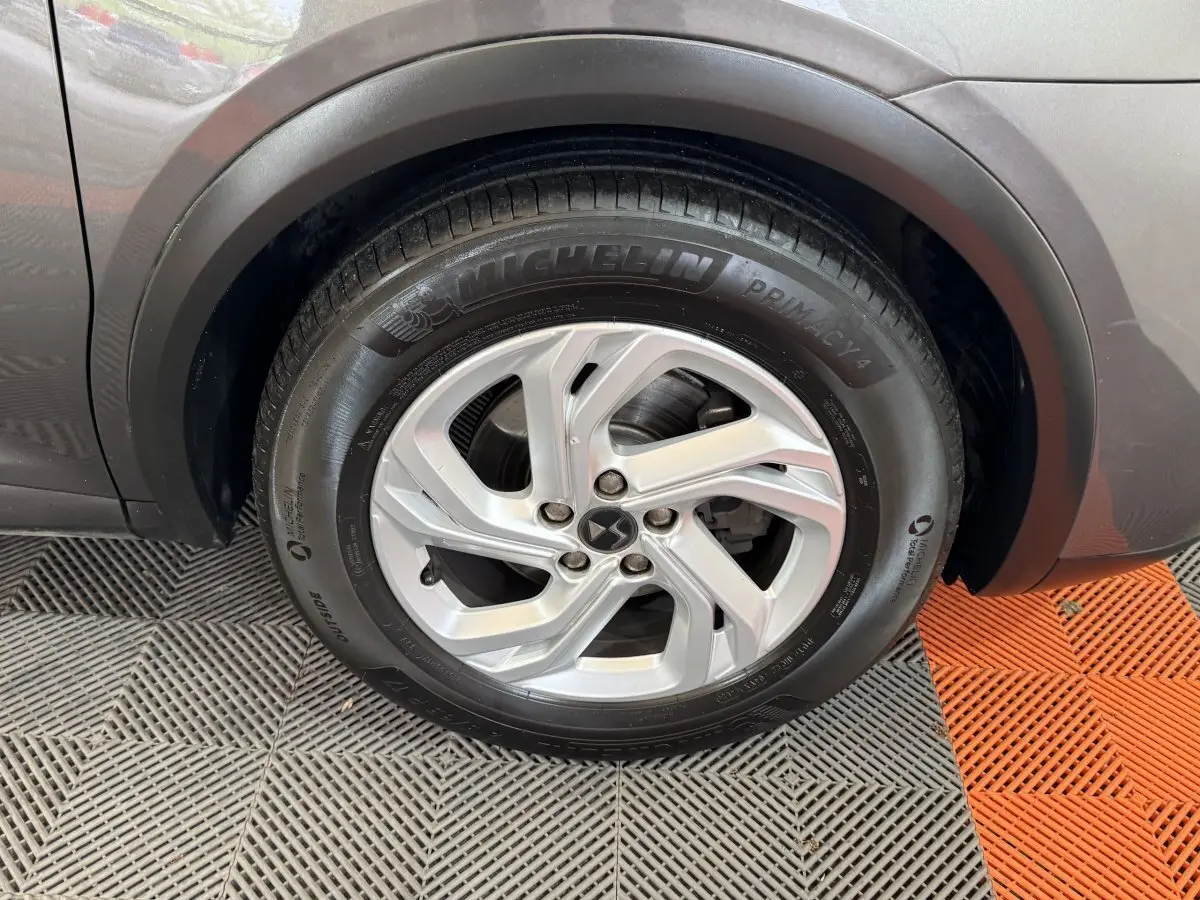 Gros plan sur la roue avant gauche du DS7 Crossback gris foncé, mettant en valeur la jante alliage et le pneu Michelin.