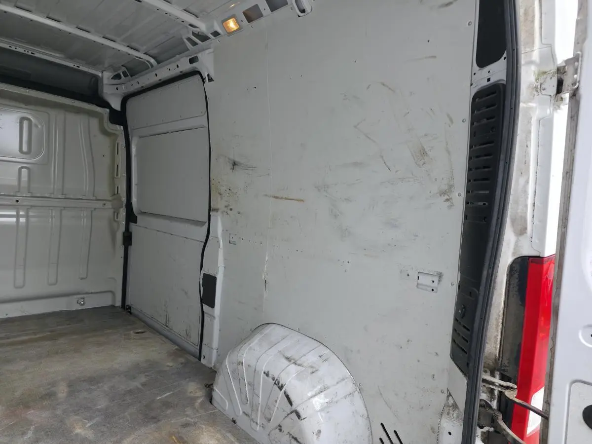 Intérieur de la cellule de chargement du Peugeot Boxer Fourgon blanc, vue côté droit avec cloison tôlée et traces d'usure.