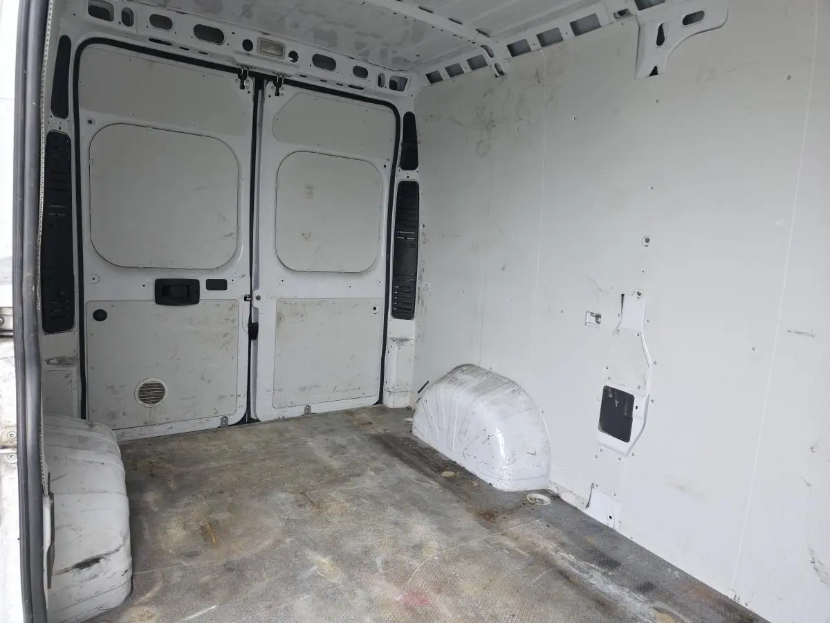 Vue intérieure de la cellule de chargement blanche du Peugeot Boxer Fourgon Asphalt 335 L2H2, montrant les portes arrière ouvertes.