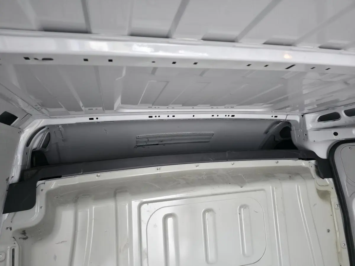 Vue intérieure de la cloison de séparation tôlée blanche du Peugeot Boxer Fourgon, version Asphalt 335 L2H2 2022.