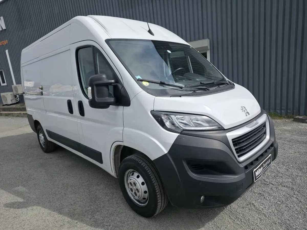 Peugeot Boxer Fourgon blanc vu en 3/4 avant droit avec pare-chocs noirs et rétroviseurs larges.