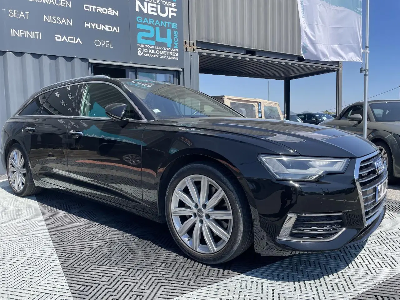 Audi A6 V Avant noir métal vue 3/4 avant droit avec jantes aluminium 10 branches et phares Full LED.