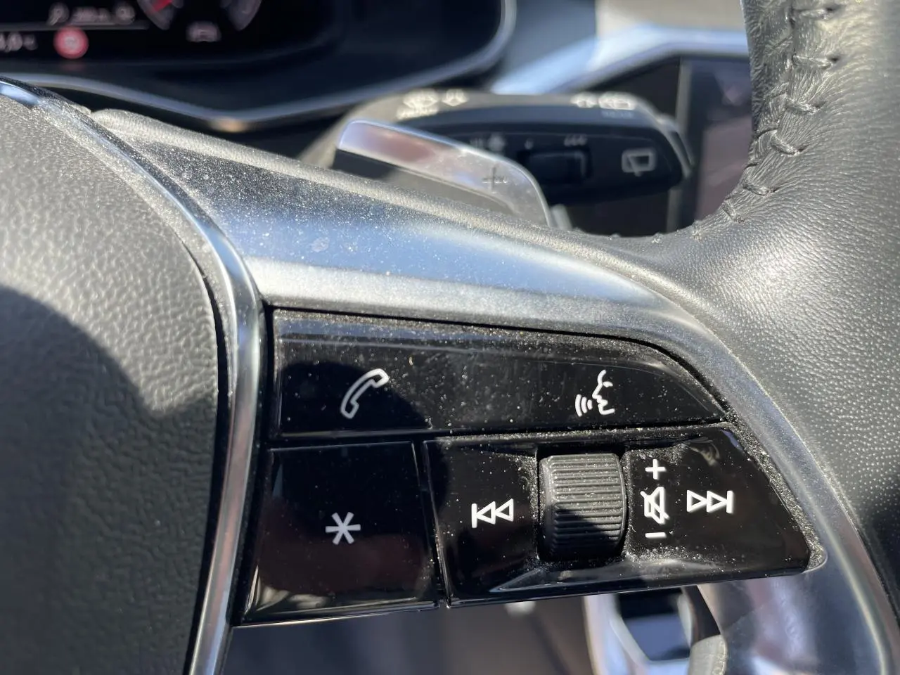 Gros plan sur les commandes multifonctions en cuir noir du volant de l'Audi A6 V Avant 45 TDI 2019.