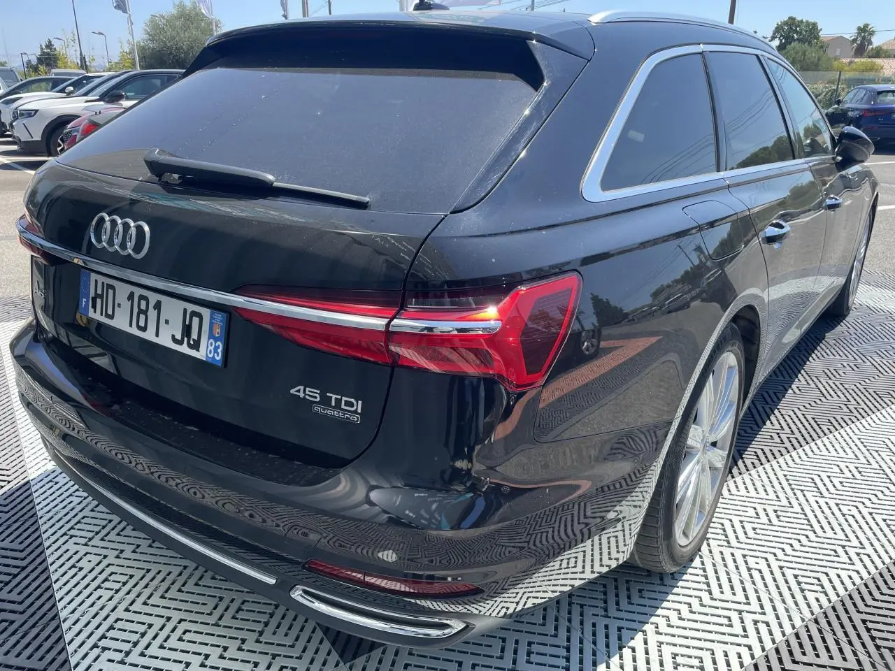 Vue 3/4 arrière droite d'une Audi A6 Avant noire métal avec feux LED et jantes aluminium 19 pouces.