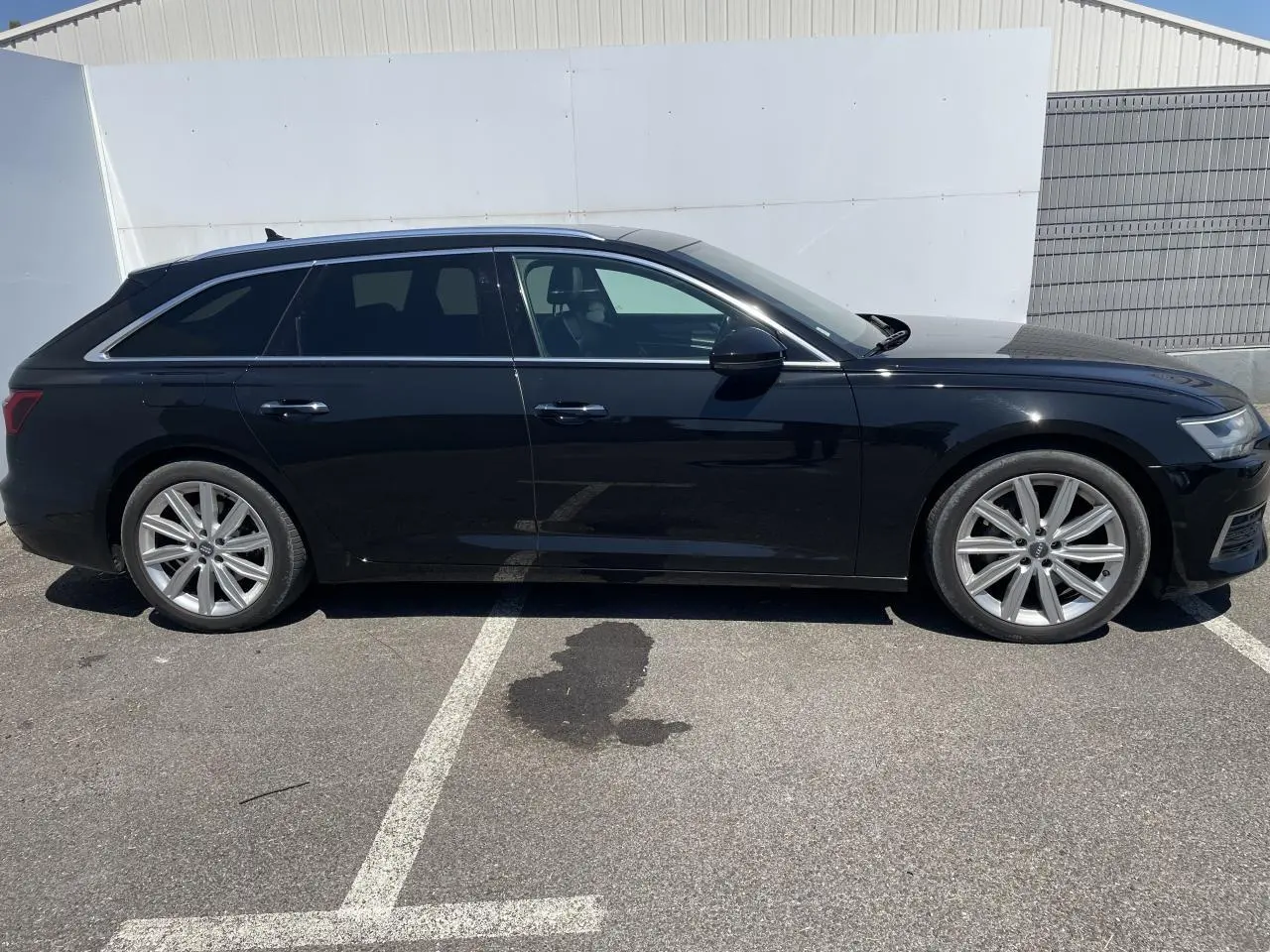 Audi A6 Avant noir métal vue de profil côté gauche, avec jantes aluminium 10 branches et vitres surteintées.