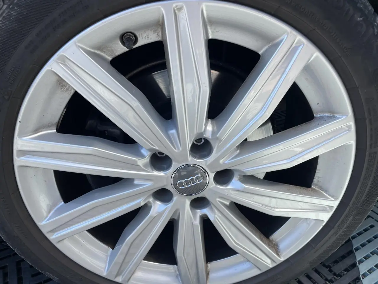 Gros plan sur une jante en aluminium 10 branches de couleur argentée d'une Audi A6 noire 2019.