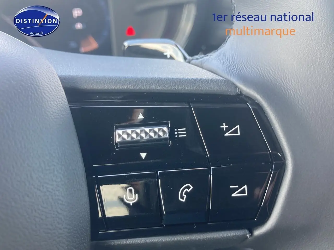 Gros plan sur les commandes vocales et téléphone au volant de l'Alfa Romeo Junior 1.2 hybride gris/noir, intérieur moderne.