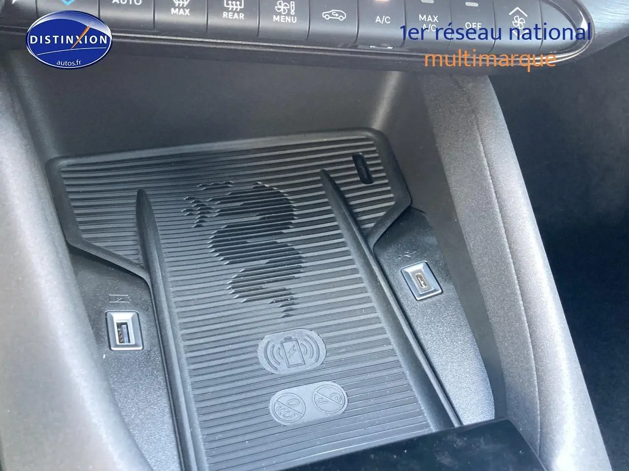 Détail du chargeur à induction noir avec logo serpent Alfa Romeo dans l'habitacle de l'Alfa Romeo Junior 1.2 hybride.