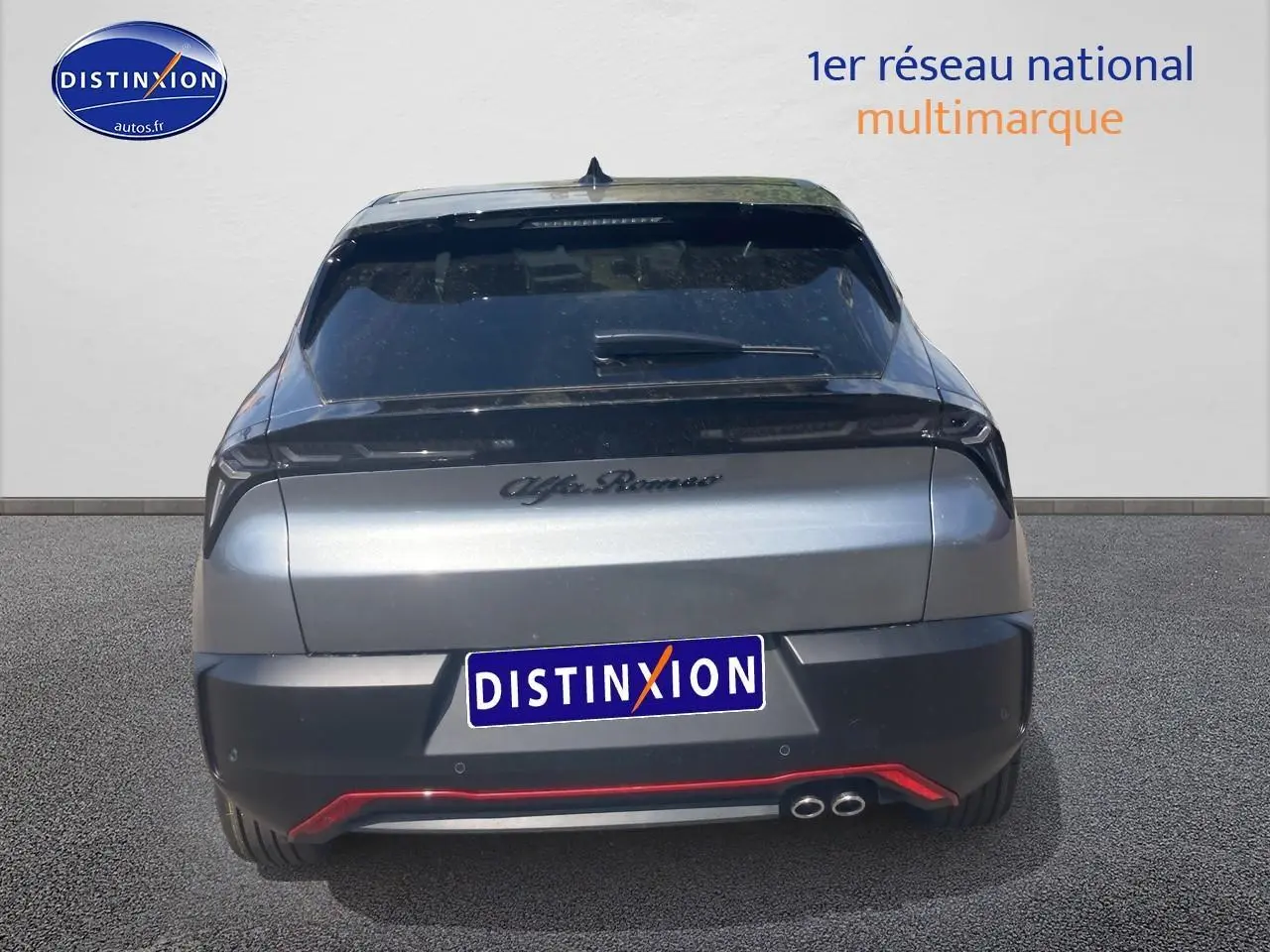 Vue arrière d'une Alfa Romeo Junior 1.2 hybride gris foncé avec double sortie d'échappement et lunette arrière teintée.