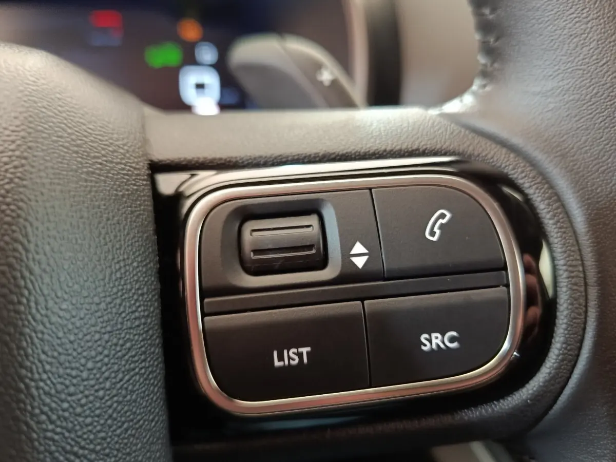 Gros plan sur les commandes multifonctions du volant cuir du Citroën C5 Aircross 2024, finition BlueHDi noir.