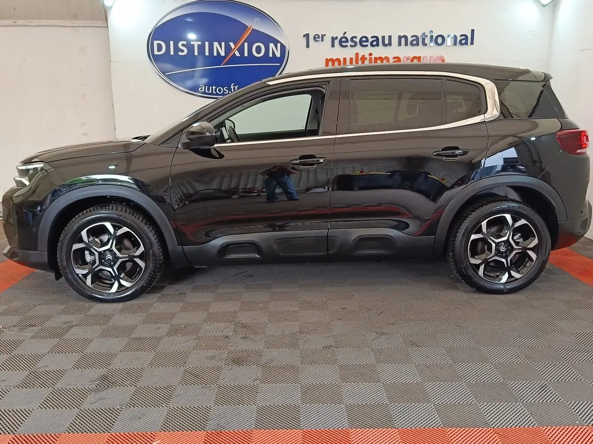 Profil droit d'un Citroën C5 Aircross noir 2024 avec toit clair et jantes alliage au design moderne.