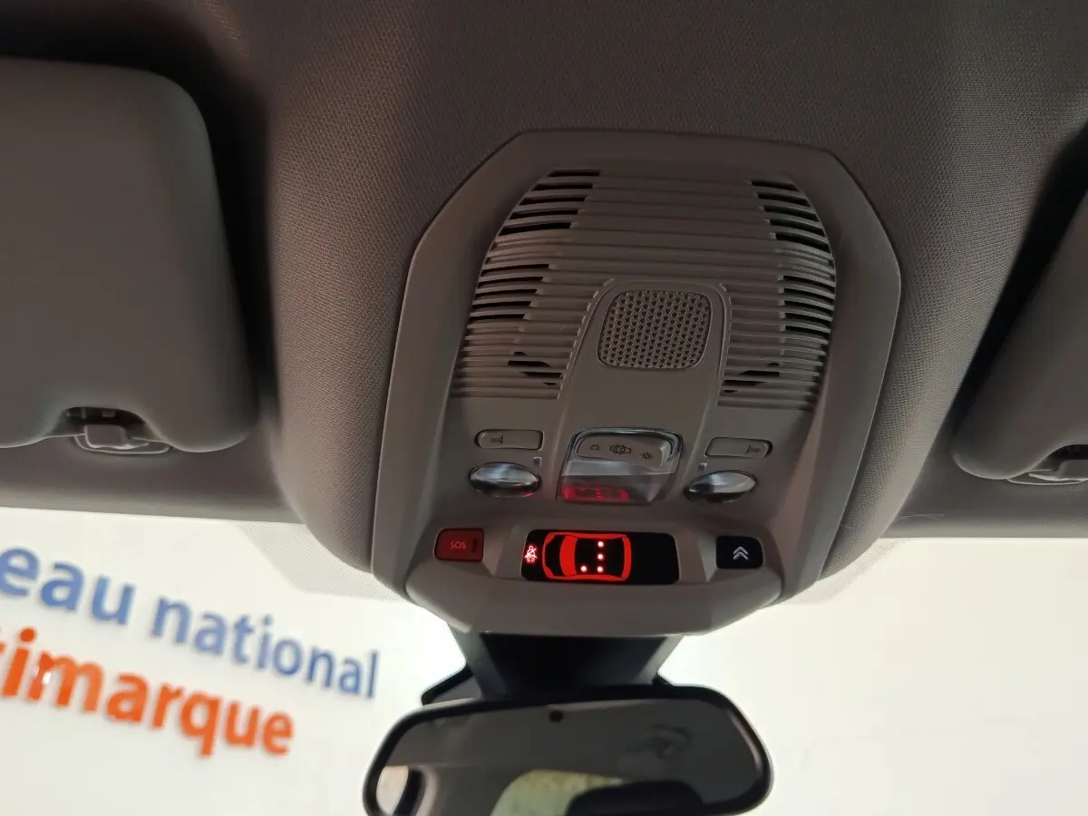 Vue intérieure du plafonnier gris clair avec commandes d’éclairage et bouton SOS du Citroën C5 Aircross 2024 noir.