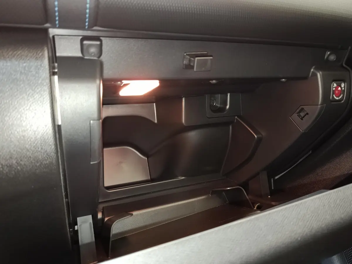 Intérieur du vide-poches ouvert côté passager du Citroën C5 Aircross noir, éclairage intérieur visible.