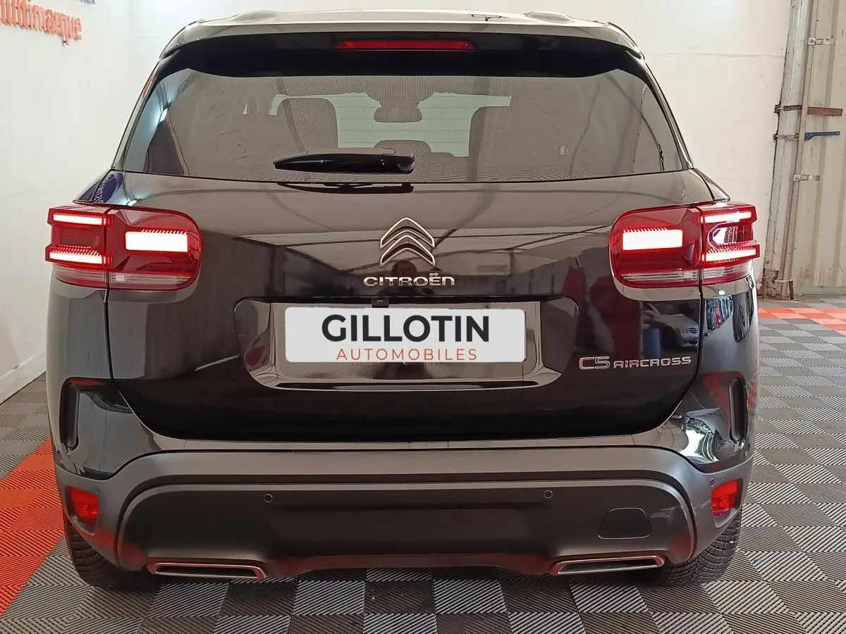 Vue arrière d'un Citroën C5 Aircross noir 2024 avec feux LED allumés et double sortie d'échappement visible.