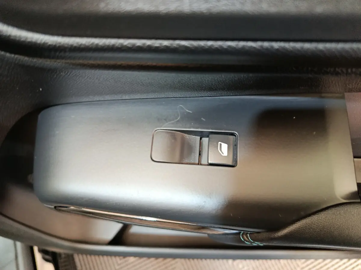 Bouton de commande de lève-vitre noir sur la portière intérieure d'un Citroën C5 Aircross 2024.