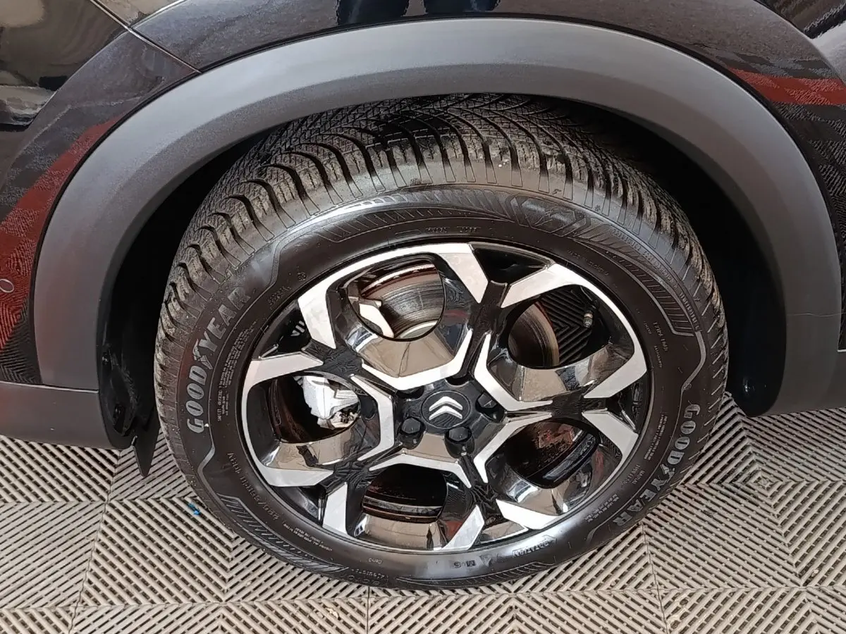 Gros plan sur la roue avant gauche noire d’un Citroën C5 Aircross 2024 avec jante alliage au design moderne.