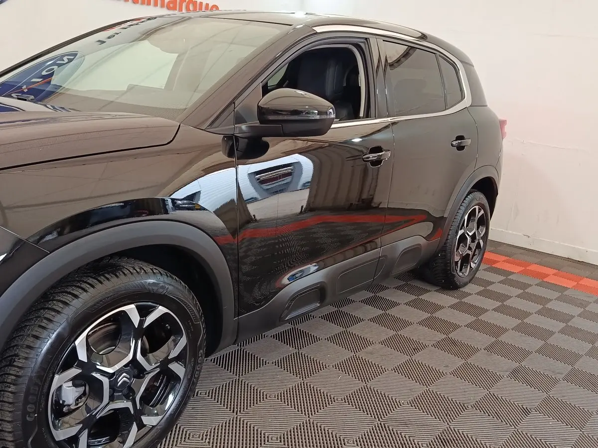 Vue côté droit en 3/4 arrière d'un Citroën C5 Aircross 2024 noir avec jantes alliage au design moderne.