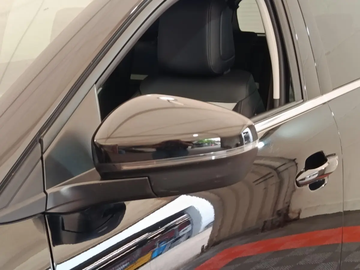 Gros plan sur le rétroviseur côté gauche et la porte noire brillante d'une Citroën C5 Aircross 2024.
