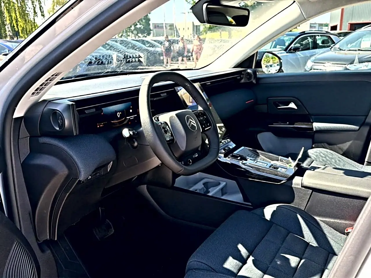 Vue intérieure côté conducteur du Citroën C5 Aircross blanc, avec tableau de bord numérique et volant multifonction.
