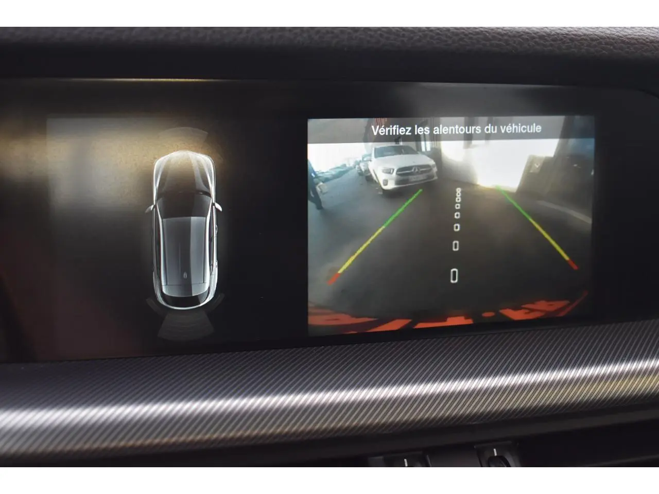 Écran intérieur montrant la caméra de recul et la vue 360° du SUV Alfa Romeo Stelvio gris Vesuvio en stationnement.