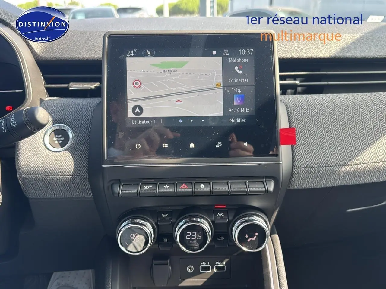 Vue rapprochée du tableau de bord de la Renault Clio V gris schiste, avec écran tactile et commandes de climatisation.