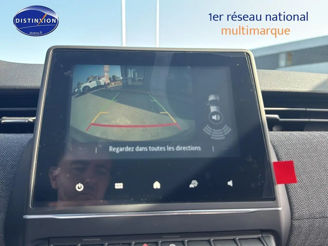 Écran tactile intérieur montrant la caméra de recul d'une Renault Clio V gris schiste, vue de face du tableau de bord.