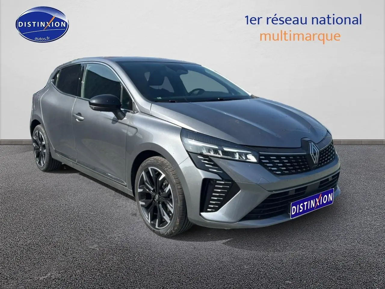 Renault Clio V gris schiste en 3/4 avant droit avec jantes alu et calandre chromée visible.