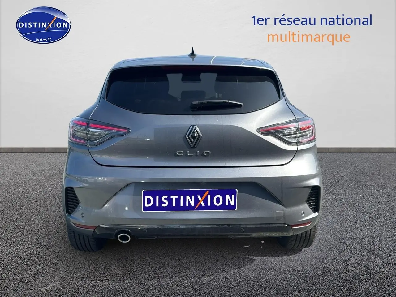 Vue arrière d'une Renault Clio V gris schiste avec feux LED et sortie d'échappement chromée visible.